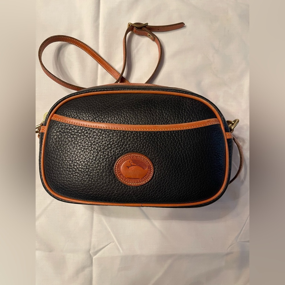 Dooney & Bourke shoulder bag in black with tan trim.